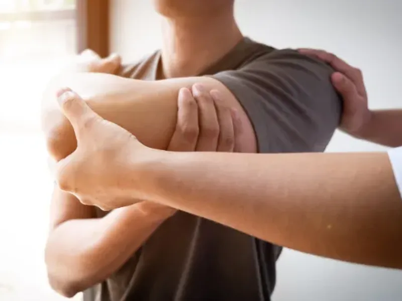 Physical therapist assessing a patient's shoulder and rotator cuff